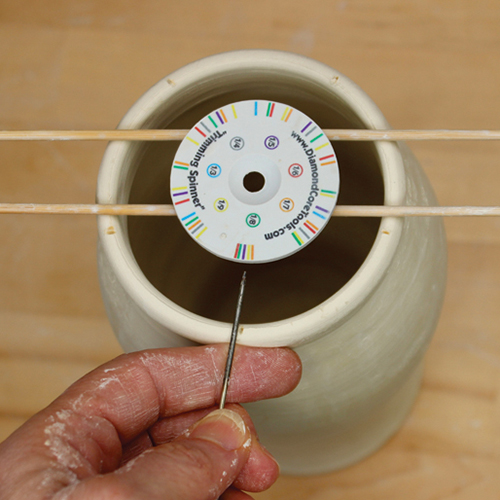2 Center a Trimming Spinner over the rim using chopsticks. Mark the rim into fifths.