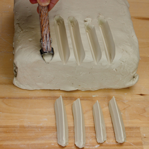 3 Pull the extruder tool through clay to create 2-inch-long appliques (5 total).