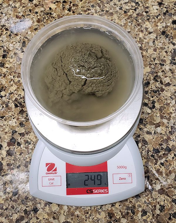 3 Slowly sprinkle the dry bentonite into the water. Do not agitate the container.