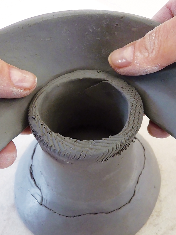 3 Complete the base with an arced coil, and gently flare it out with your fingers.
