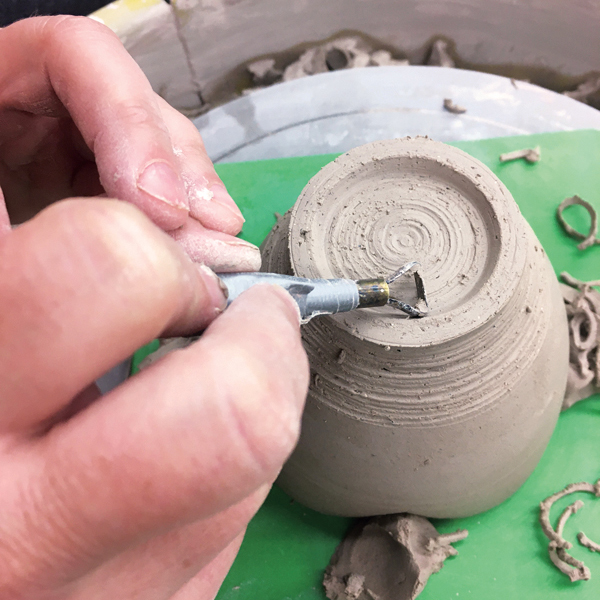 3 When it is leather-hard, trim a hidden foot onto the bottom of the cup.