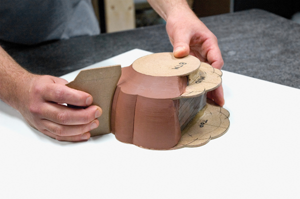 Armature packed with clay and modeled with hardboard template.