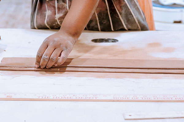 4 Roll or extrude a coil approximately ⅜ inch in thickness to create a gallery for the lid. Score, slip, and attach this coil on the unstamped side of the slab,½ inch below the top.