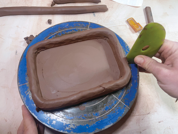4 Using a stiff rib, compress the edges of the coil on the outside and inside of the box to secure the connection.