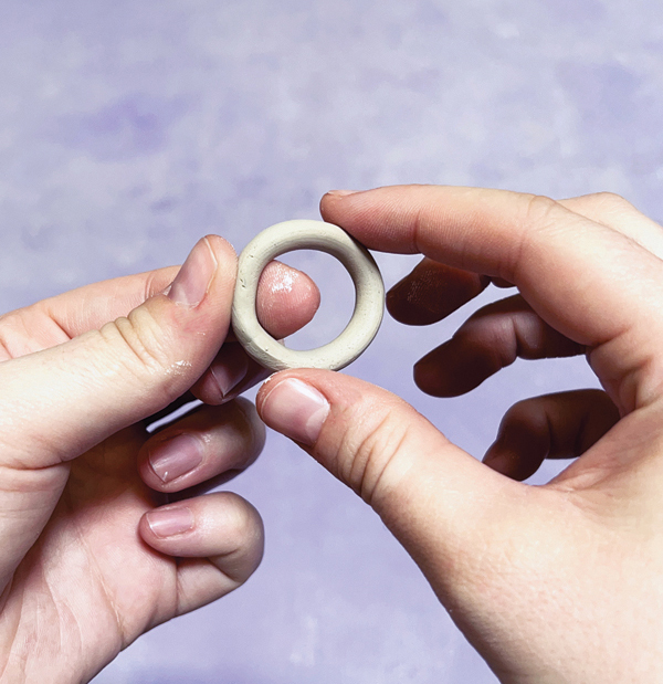 4 Smooth together the ends of a coil and slowly roll it into a circular curve.