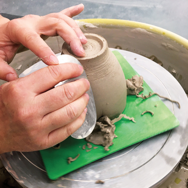 4 Use a smooth metal rib to polish the trimmed exterior of the cup.