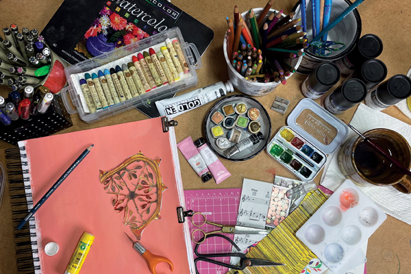 5 Tabletop with multiple materials for sketchbook exploration and studio prep work.