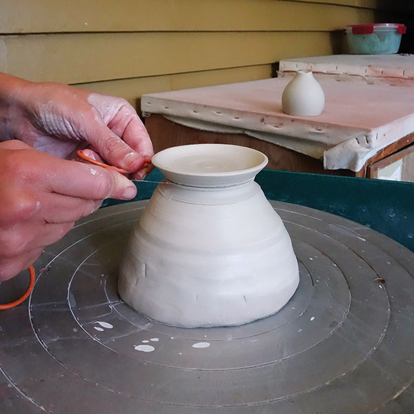 6 Throw a saucer off the hump and add a lip. Cut under the saucer with a wire tool.