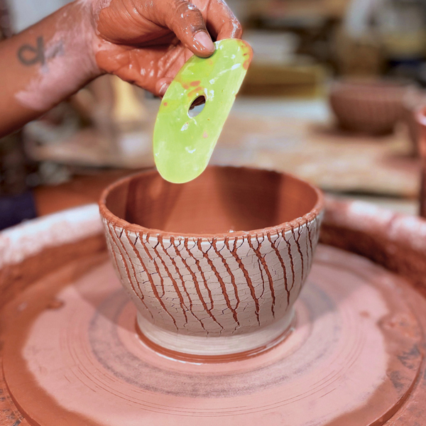 6 Compress and shape the stretching clay by placing a soft rib on the inside of the bowl and applying even outward pressure.