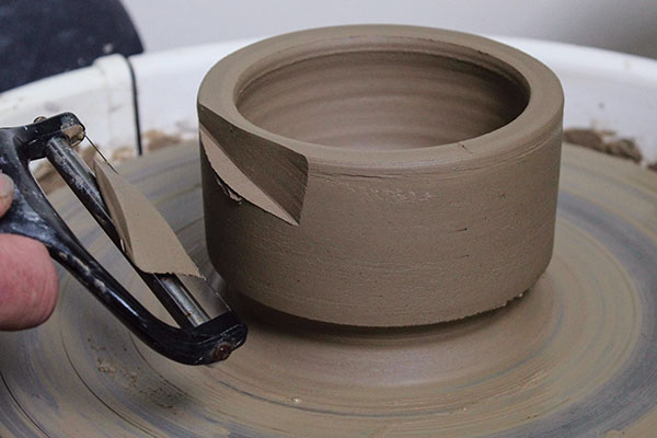 6 Hold the cutter at an angle and draw it quickly through the clay to create a zig-zag pattern around the form. 