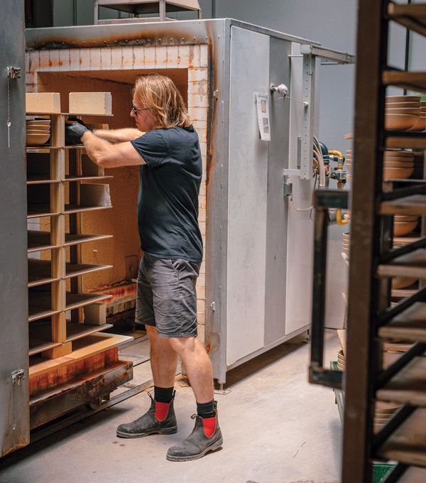 G Bill Campbell, production support, unloading a bisque kiln. Photo: Mike Belleme.