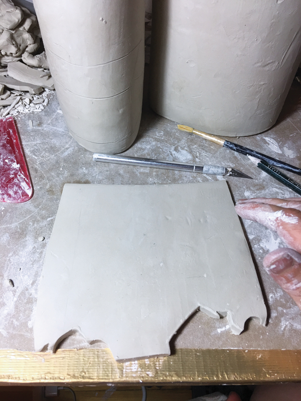 7 The removed piece of clay is gently flattened to be reattached later.