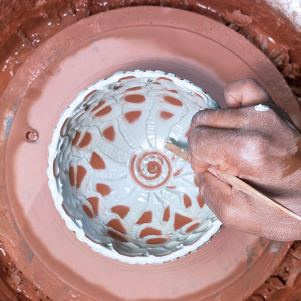 7 Tap the slip with a wooden tool, spoon, or soft rib to create impressions, and reveal clay through the slip. 