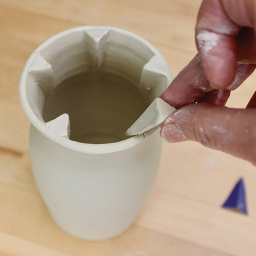 8 Score and slip both pieces along the marks, then attach the appliques inside.