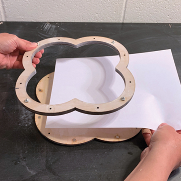 1 Place a sheet of paper on the base of the mold and attach the outer wooden ring.