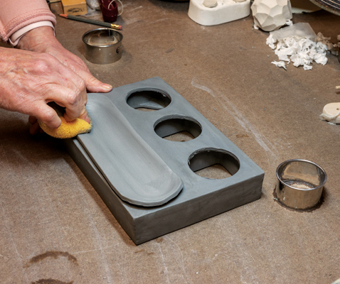 11 Position a fresh slab over the tray area. Use a damp sponge and press down on the clay to form a concave curved tray.