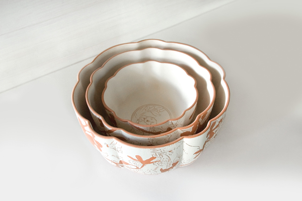 Bowls with burrs from the sgraffito process removed, sanded, and bisque fired to cone 09.