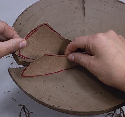 7 This first cut and alteration begins the illusion of movement that will be accentuated as the building progresses. Mimicking the curve of the cut and altered base, the bottoms of the templates are predetermined and cut to fit. These two templates/slabs define the way the rest of the pot will develop.