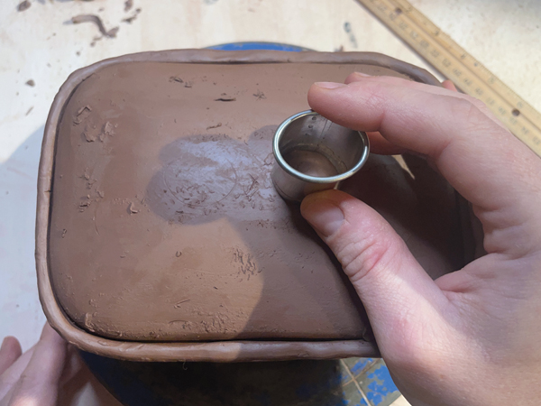 14 Use a small oval cookie cutter to mark two circles on either side of the center mark. Cut out the circles.