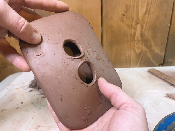 15 Use your fingers to stretch the handle so it is raised, then pinch the sides together to give the handle an hourglass shape.