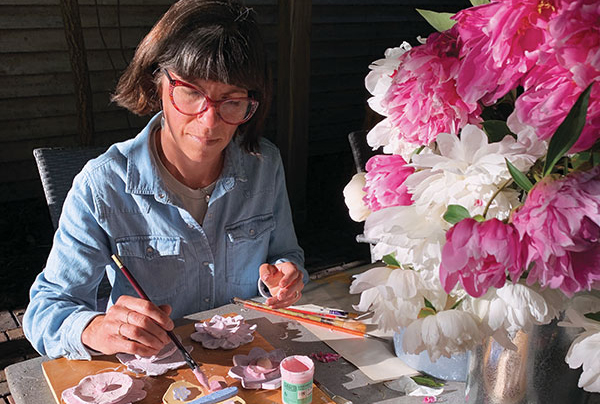 4 Erin Furimsky applying Amaco LG 10 Clear glaze over underglazed flowers made by various artists. The clay is a low-fire white talc body from Standard Ceramic.
