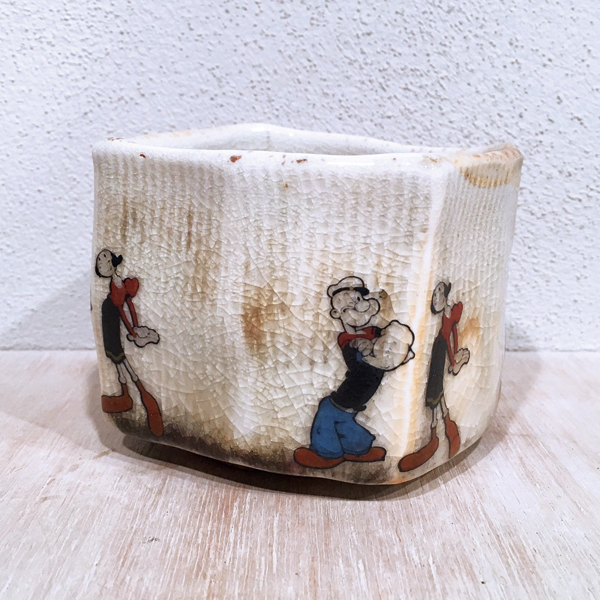 7 Popeye & Olive Oil Teabowl, 4 in. (10 cm) in height, wheel-thrown and faceted porcelain, Wirt’s Trap glaze, wood fired to cone 10, decals fired to cone 017, 2020.
