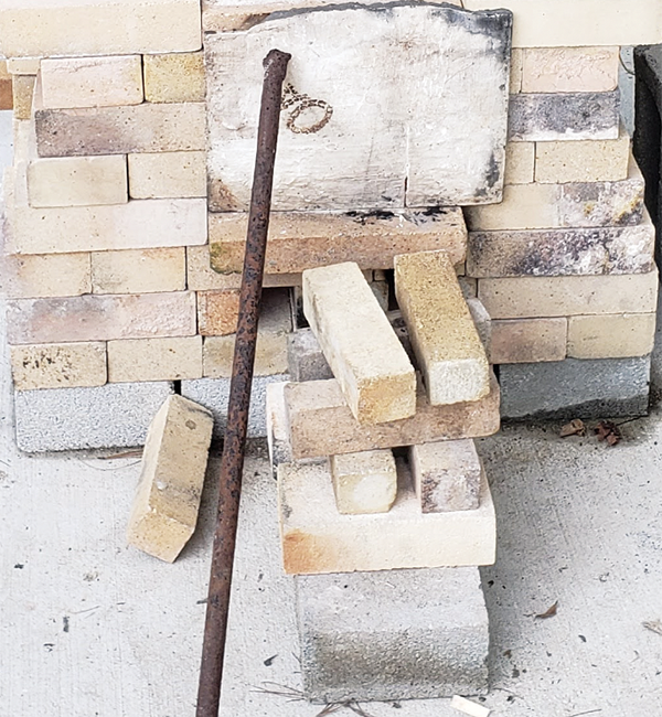 5 An old kiln shelf serves as the firebox door. A steel bar holds it in place.