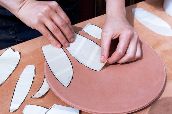 6 Sketch shapes onto the stickers, then cut them out. Affix the stickers in a design.