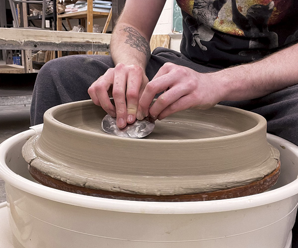 3 Use metal rib to shape and compress base, and a trimming tool to define the well and rim of the plate.