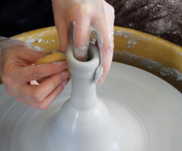 3 Make a hollow handle by throwing a tall, thin form off the hump and trapping air inside it by closing off the top.
