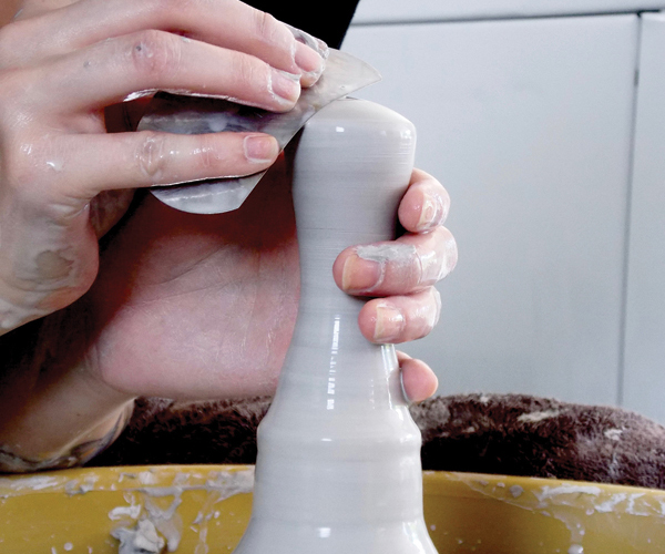 4 After closing the form and trapping air inside, refine and shape the curves of the handle using a rounded metal rib.