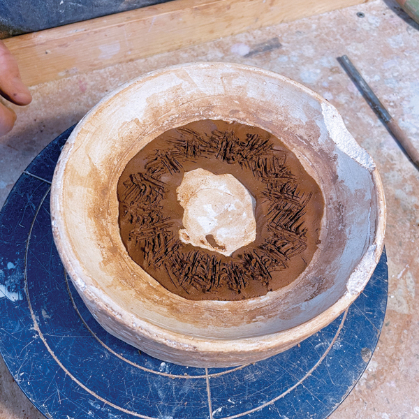 2 Score the top of the foot ring and apply slip to ensure that the base slab adheres to it. 