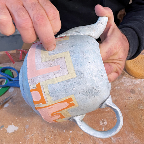 6 Peel the tape off to reveal the underglaze shapes and then refine them with a knife.