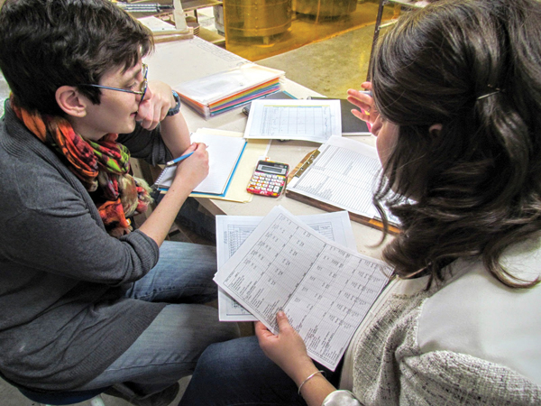 Katie Teesdale (left) and Morgan Baum reviewing a balance sheet and discussing expense management.