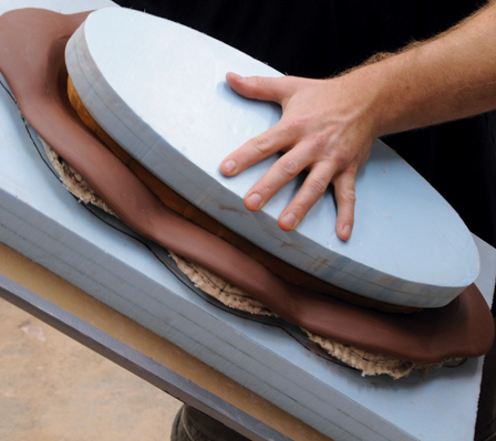 4 Sandwich the removed foam section, the cloth, and the clay (in the slump mold) between your hands, then flip over.