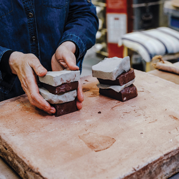 2 Stack the clay in alternating colors. Compress the clay to remove any air trapped between the chunks.