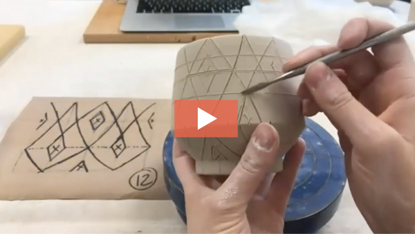 Still from video of Katie Bosley drawing pattern on cup.