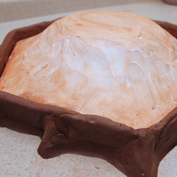 2 Pour liquid plaster over the model. When it starts to set up, manipulate it to mound up evenly over the model. 