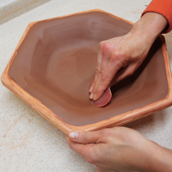 5 Use a soft rib to compress the clay, smooth the surface, and even out the wall thickness.