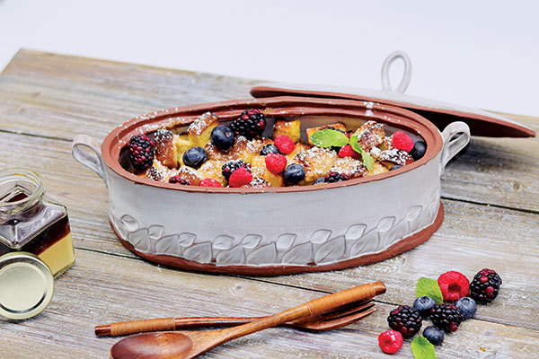 Casserole dish, 13 in. (33 cm) in length, handbuilt red earthenware clay, glaze, fired to cone 5 in an electric kiln. Shown in use, serving a French toast casserole with maple butter. 