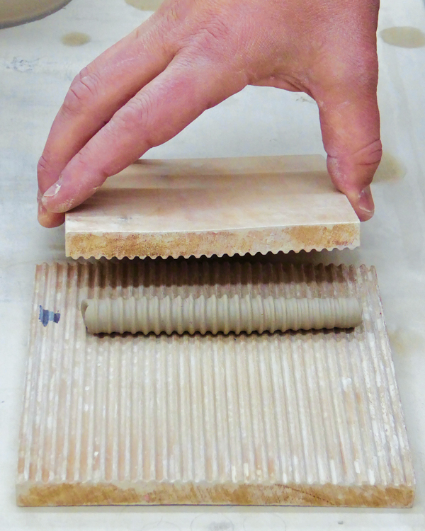 10 Roll a coil of clay between two pattern blocks to make a hose shape.