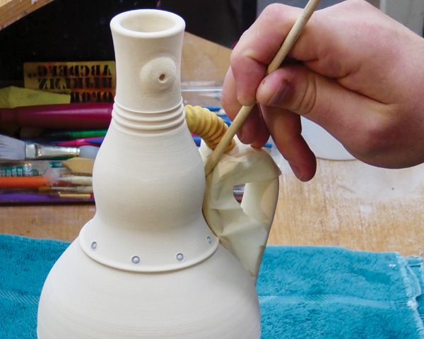 13 Mask off the handle and brush various underglazes into the rivets and the hose.