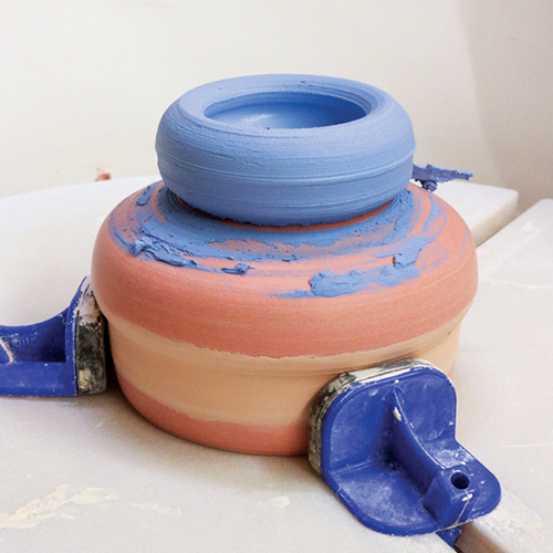 5 Center the colored ball of clay, throw it into a foot, and allow it to firm up. 