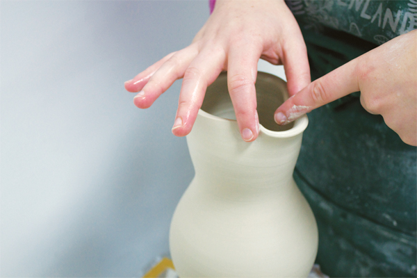 3 After pulling the spout, bevel a finger back and forth between the anchor points of the pinched mouth.