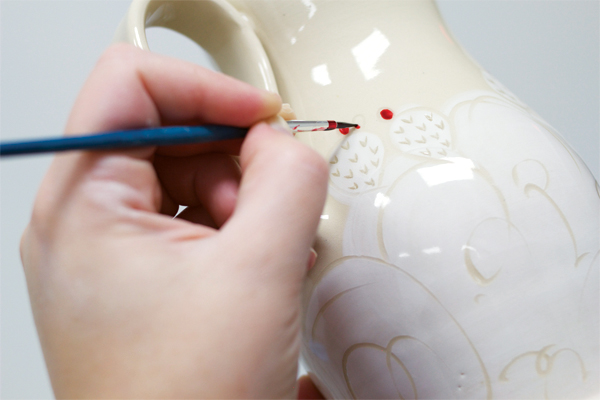 11 Paint luster on the glazed piece; filling in the outlines of the cacti bulbs adds a third layer of color and detail.