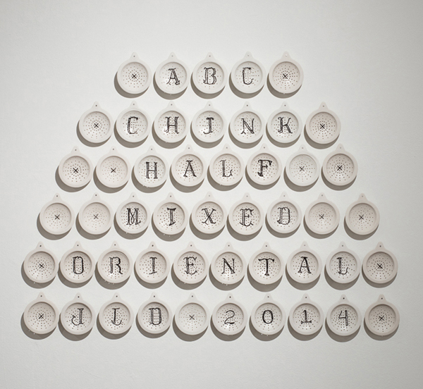 Jennifer Datchuk’s Sampler of an American Born Chinese, 3 ft. 4 in. (1 m) in height, slip-cast Laguna cone 5–6 porcelain shower drains, oxidation fired, collected hair, 2014. Photo: Mark Menjivar.