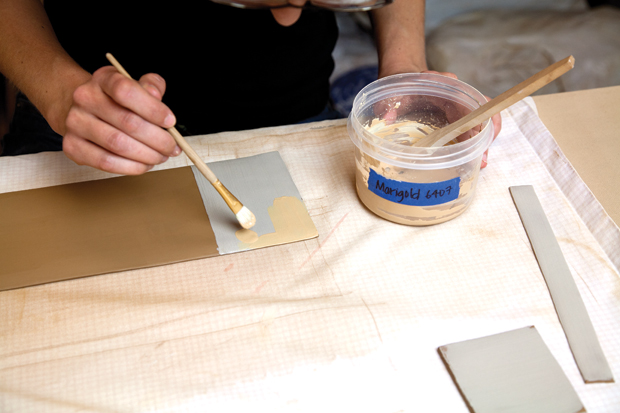 Coat the sides, base, and handle while they are flat. Start with a white low-fire slip so what is put on top becomes brighter. Apply an underglaze or wash over as a solid background color.