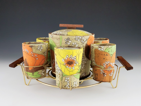 1 Ice bucket and whiskey cups with found caddy, 18 in. (46 cm) in length, red stoneware, underglaze, colored slip, glaze, fired to cone 6 in oxidation, 2021. 