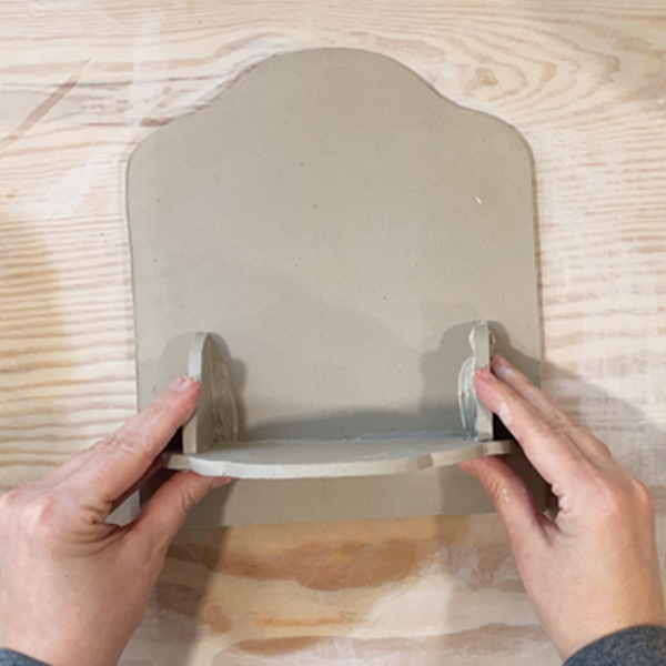 9 Attach the shelf to the back piece and smooth all of the seams.