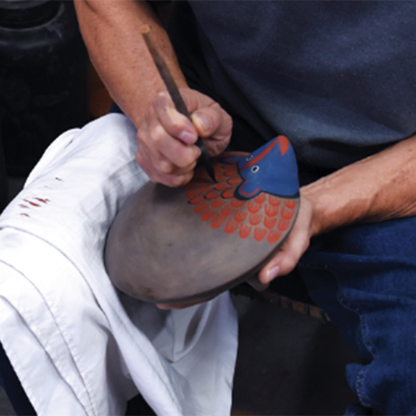 4 Painting the intricate patterning on an armadillo churumbela form.
